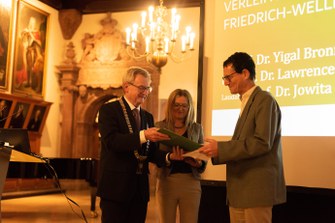 Öffentliche Frühjahrssitzung 2023, Bild 4 Verleihung des Friedrich-Weller-Preises an Prof. Dr. Yigal Bronner (im Bild) und Prof. Dr. Lawrence J. McCrea durch Prof. Dr. Jowita Kramer, Universität Leipzig (Laudatio) und Prof. Dr. Hans Wiesmeth (SAW), Foto: Dirk Brzoska