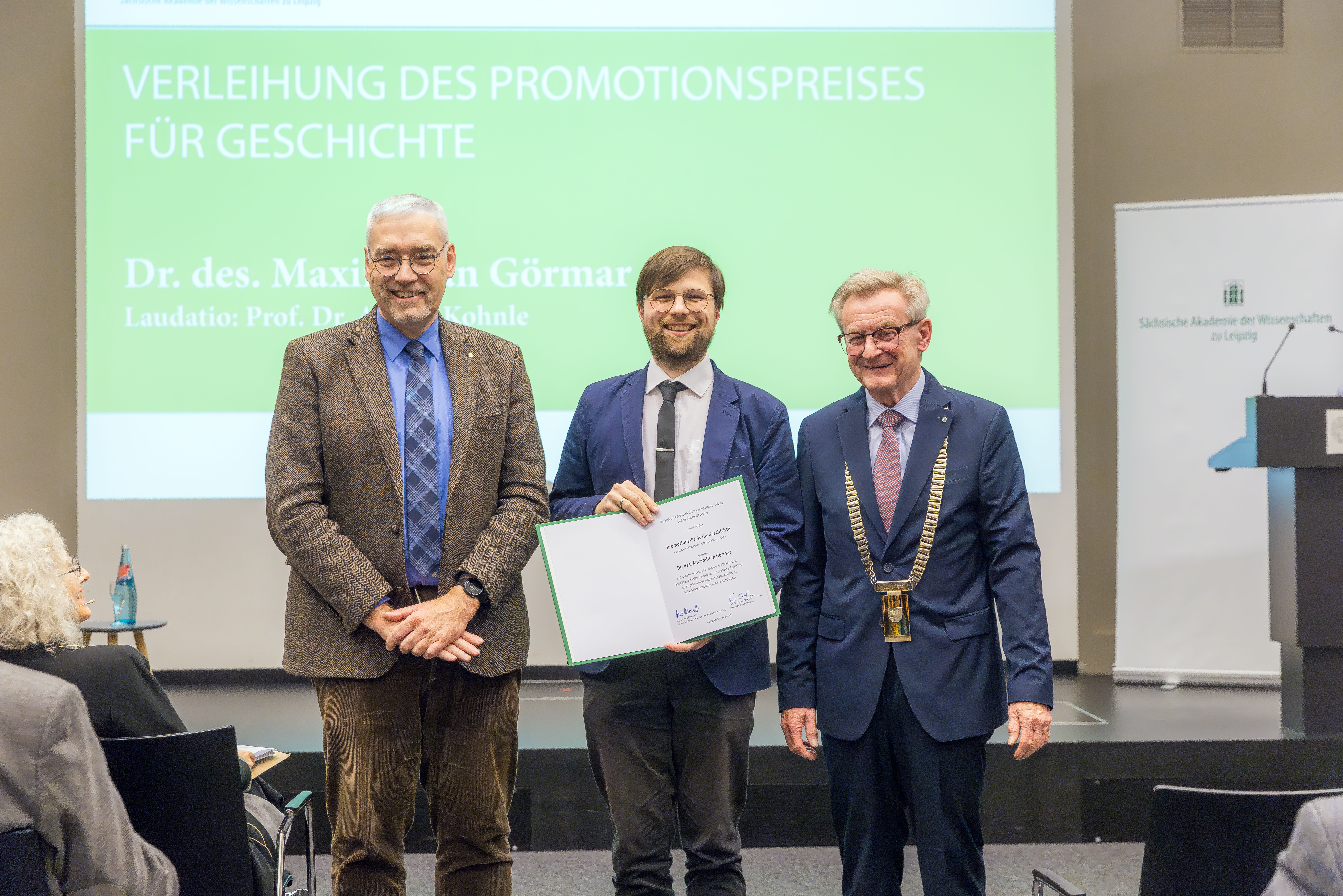 Dr. des. Maximilian Görmar (Mitte) bekommt den Promotionspreis verliehen. Links: Prof. Dr. Armin Kohnle, rechts: Prof. Dr. Hans Wiesmeth.