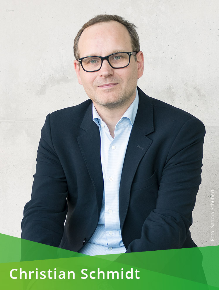 Farbporträt einer männlichen Person mit Brille. Auf dem unteren Bildrand steht auf grünem Hintergrund: Christian Schmidt. Im Bild steht außerdem: Foto: Sandra Schubert.
